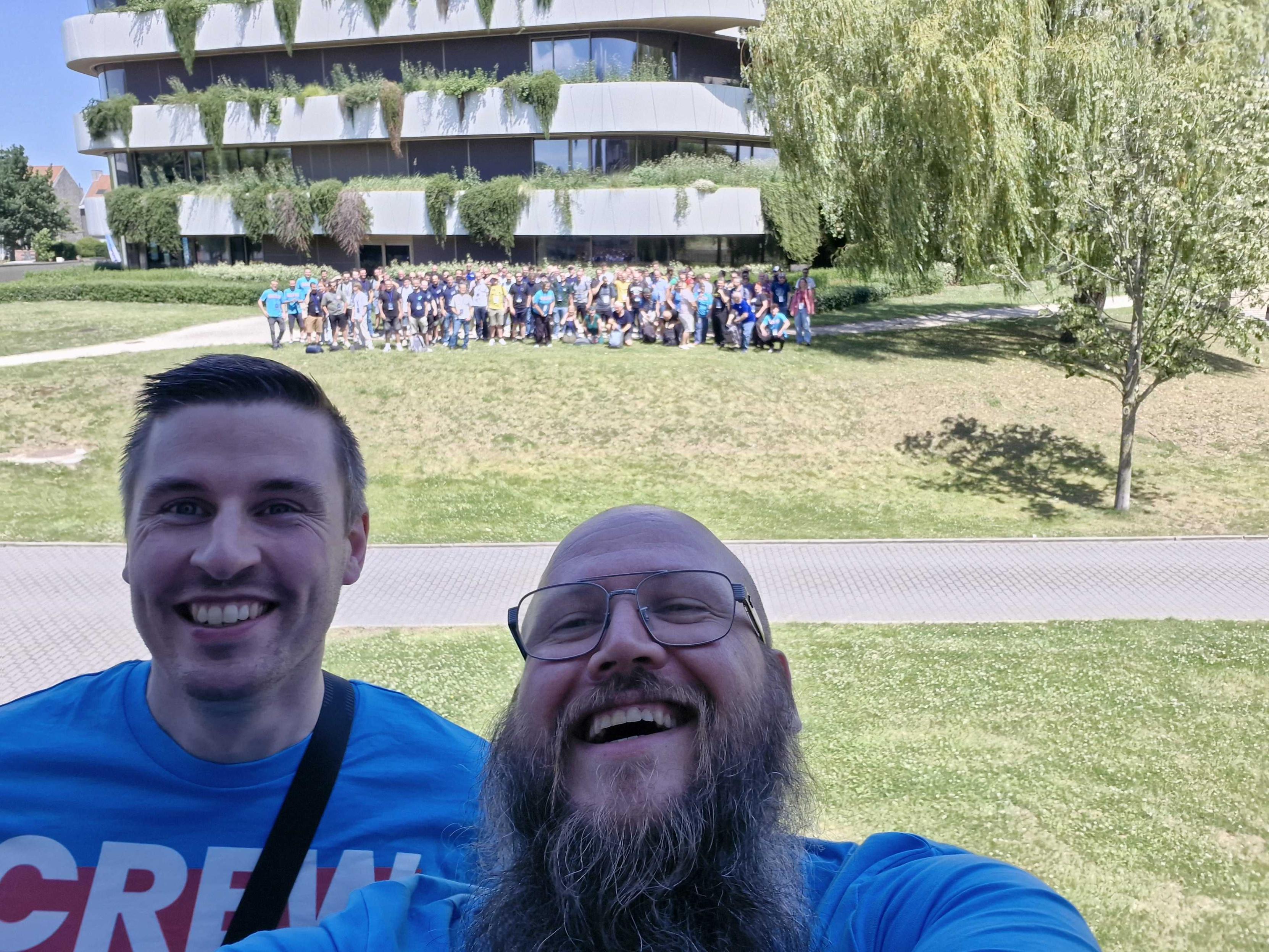 Selfie by Joris & Bram with Drupalcamp Kortrijk attendees in the background - after the group photo has been taken